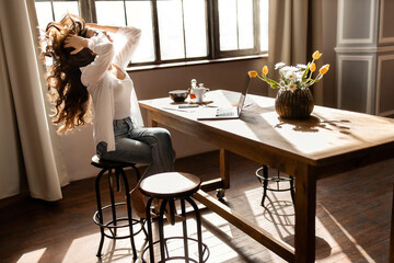 Young business woman working on laptop with phone from home 