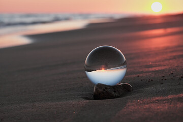 Sfera di cristallo sulla spiaggia della puglia al tramonto