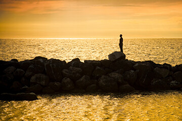 The man and the sea into the sunset - concept image - silhouette style background