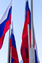 Russian flag waving against the blue sky and white clouds. Symbol of Russia, russian authority concept.