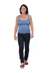 Fototapeta premium full portrait of a woman walking and with casual clothes on white background, front view