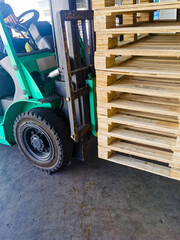 Naklejka premium Worker driving forklift to loading and unloading wooden pallets from truck to warehouse cargo storage, shipment in logistics and transportation industrial, wood pallets stack