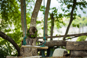 Wooden swing in the garden for relaxation with blur background