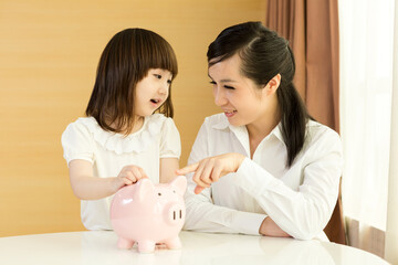 Obraz na płótnie Canvas Parents teaching daughter to save money at home