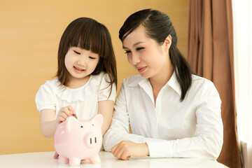 Obraz na płótnie Canvas Parents teaching daughter to save money at home