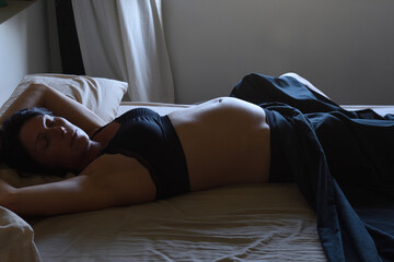 pregnant woman lying in bedroom