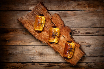 Chocolate Neapolitans on cork on top of a wooden table