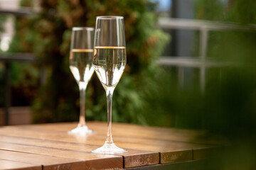 Glasses of sparkling champagne on wooden table. Warm. Celebration event, holidays, drinks concept. Companion for best family or friend's memories. Anniversary, wedding day or Christmas time.