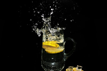 Fototapeta na wymiar ice water splash with lemon slices isolated on black background - high speed photography