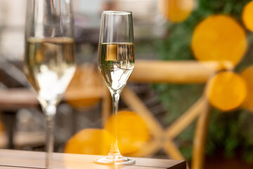 Glasses of sparkling champagne with bokeh, close up. Warm. Celebration event, holidays, drinks concept. Companion for best family or friend's memories. Anniversary, wedding day or Christmas time.