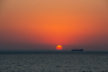 Fototapeta na wymiar Silhouette of a fishing ship on a background of sunrise. Sunrise in the morning by the sea.