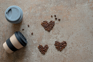 Coffee cups on cement background with coffee beans heart. top view