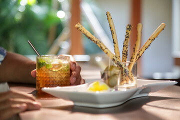 Salty sticks and iced tea served on the restaurant table.