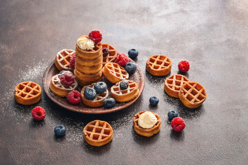 Homemade waffles with berries. Traditional Belgian mini waffles with blueberries and raspberries. Selective focus.