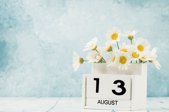 White cube calendar for august decorated with daisy flowers