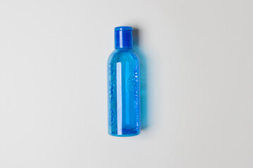 blue bottle with tonic for health care on yellow colored paper background