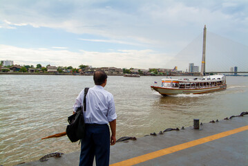man on a pontoon waiting for the speed boat on the Chao Phraya River in Bangkok, Thailand