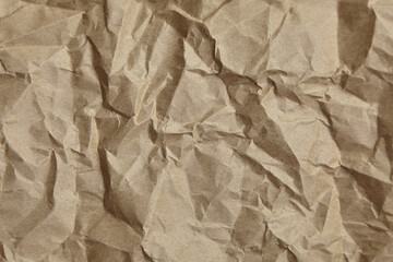 Crumpled paper, texture, background. Brown craft paper with wrinkled pattern