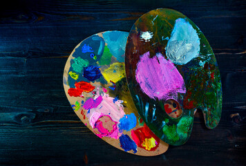 Obraz na płótnie Canvas 2 palette of paint colors isolated on dark wooden table surface top