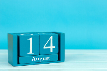 wooden calendar with the date of August 14 on a blue wooden background