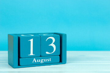 wooden calendar with the date of August 13 on a blue wooden background, World Left Handed Day