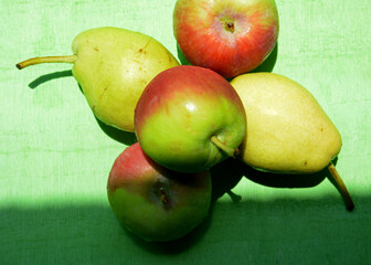 apples and pears on green background