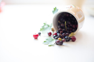 Berries in beautiful vintage dishes - still life on a white background, currants, raspberries and cherries-summer harvest. Beautiful mugs.