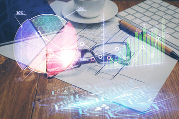 Financial chart hologram with glasses on the table background. Concept of business. Double exposure.