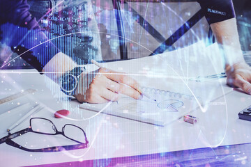 Double exposure of Man writing in notepad with business icons on background.