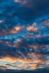 Beautiful clouds in blue sky, illuminated by rays of sun at colorful sunset to change weather. Soft focus, motion blur abstract meteorology background.