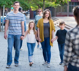 Friendly and glad family going in a park on the weekend together