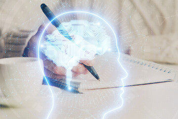 Multi exposure of writing hand on background with brain hologram. Concept of learning.