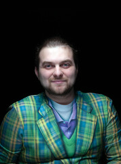 Fototapeta premium handsome positive stylish bearded man in green checkered blazer looking at camera isolated on black