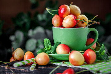 Fresh cherry in a Cup on a dark rustic wooden table. Background with space for copying. Selective focus.