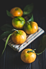 Tangerines with leaves on an old fashioned country table. Selective focus. Vertical.