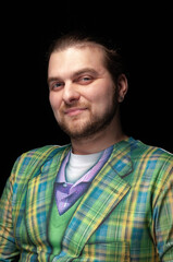 confident stylish bearded man in green checkered blazer looking at camera isolated on black