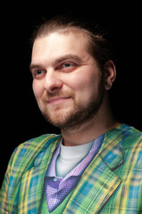 Obraz premium portrait of smiling cheerful stylish bearded man in green checkered blazer looking away isolated on black