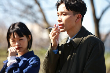タバコを吸う男性と嫌がる女性