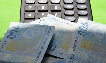 calculator and one hundred Turkish lira banknote