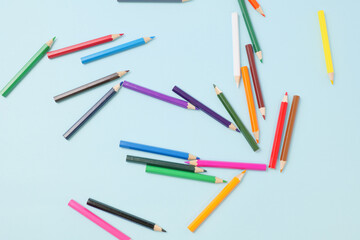青い背景に置いたカラフルな色えんぴつ