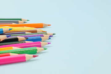 青い背景に置いたカラフルな色えんぴつ