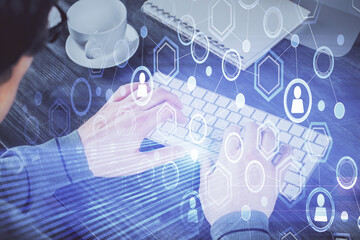 Social network theme hologram with businessman working on computer on background. Multi exposure.