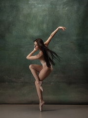 Artwork. Graceful classic ballerina dancing on dark studio background. Pastel bodysuit. The grace,...