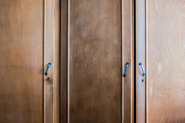 vintage wooden closet doors of a wardrobe with knobs and keys