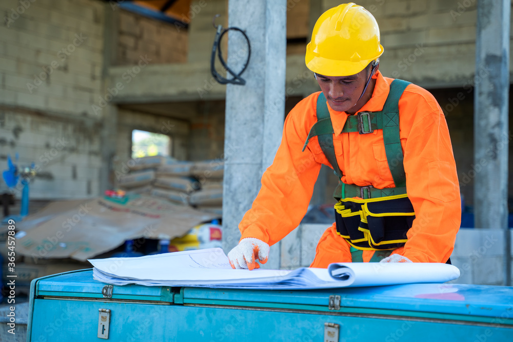 Leinwandbilder engineer at work with blueprints in front of a construction site.