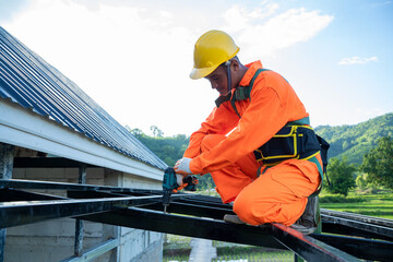 Professional technical workers working install new roof,Roofing tools,Electric drill used on new roofs with Metal Sheet.