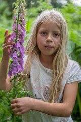 Mädchen beim Erforschen, Betrachten eines hoch giftigen  Roten Fingerhutes (Digitalis purpurea)...