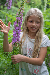 Mädchen beim Erforschen, Betrachten eines hoch giftigen  Roten Fingerhutes (Digitalis purpurea)...