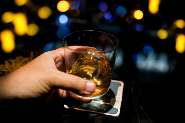 Glass of scotch whiskey on blurred background.