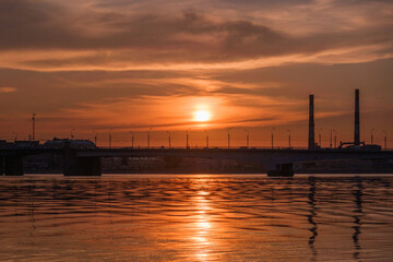 colorfull sunset above river and bridge in summer evening